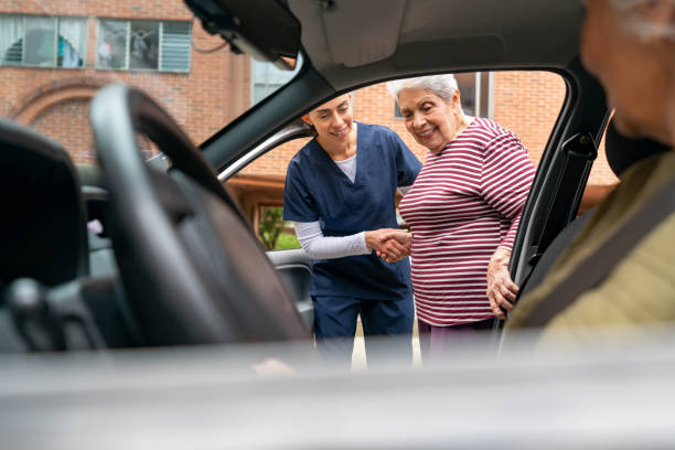 One of our team helping a happy senior woman get inside a car