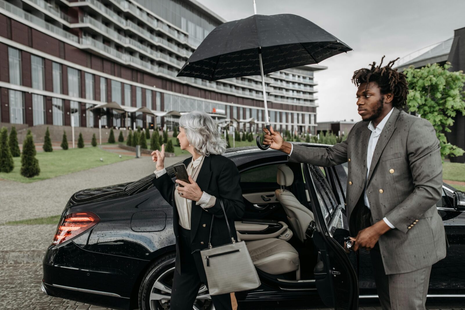 A man holding an umbrella and walking to a door